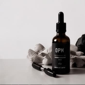 A dropper bottle of DPM oil on stone
