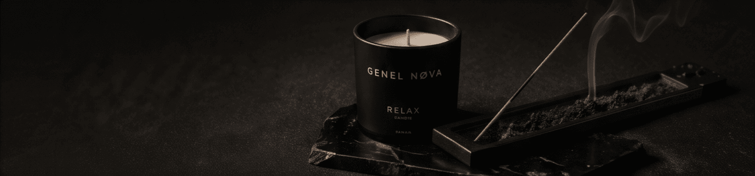 A Relax candle burning beside a smoking incense tray on black marble