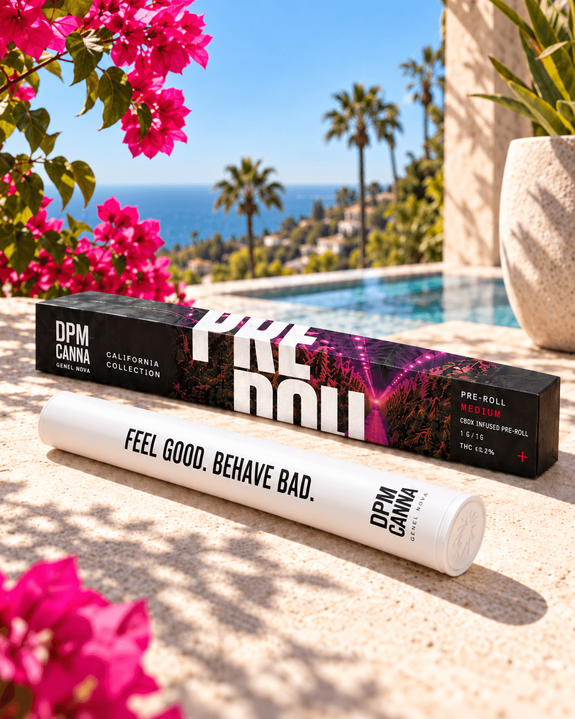 A white pre-roll tube printed Feel Good. Behave Bad. in front of its box among bougainvillea